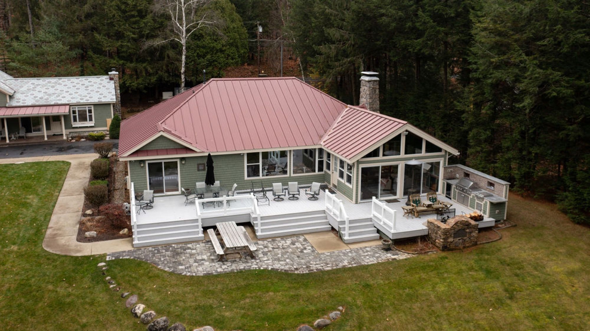 Aerial view of the main house deck, outdoor kitchen, and stone patio at Camp Sunnyside.