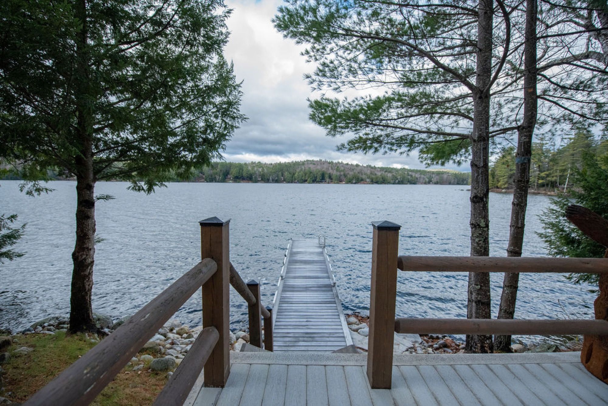 Steps leading down to the dock at Camp Sunnyside, framed by hemlocks on Friends Lake.