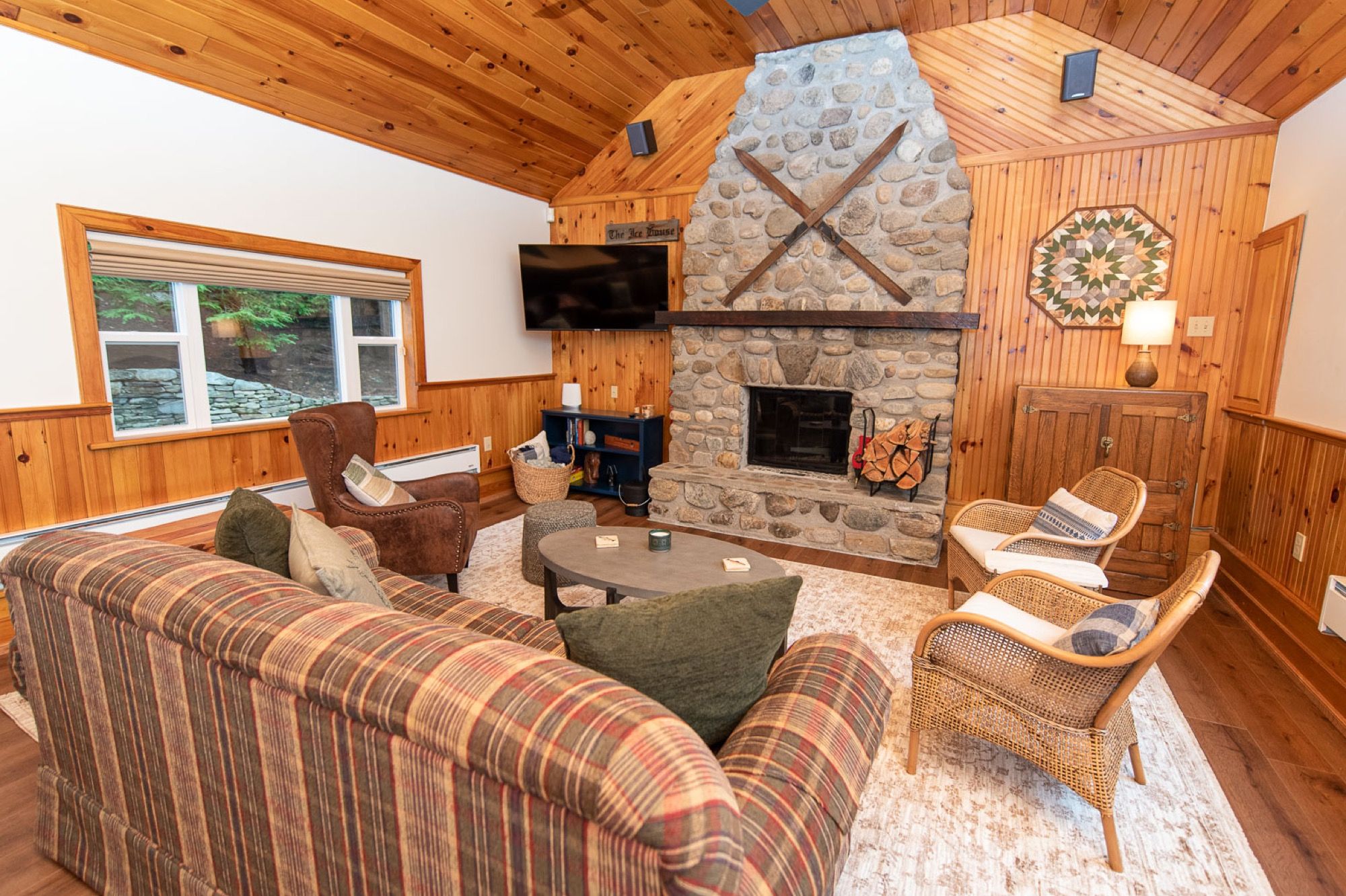 A stone fireplace with crossed antique skis in a lounge at Camp Sunnyside.