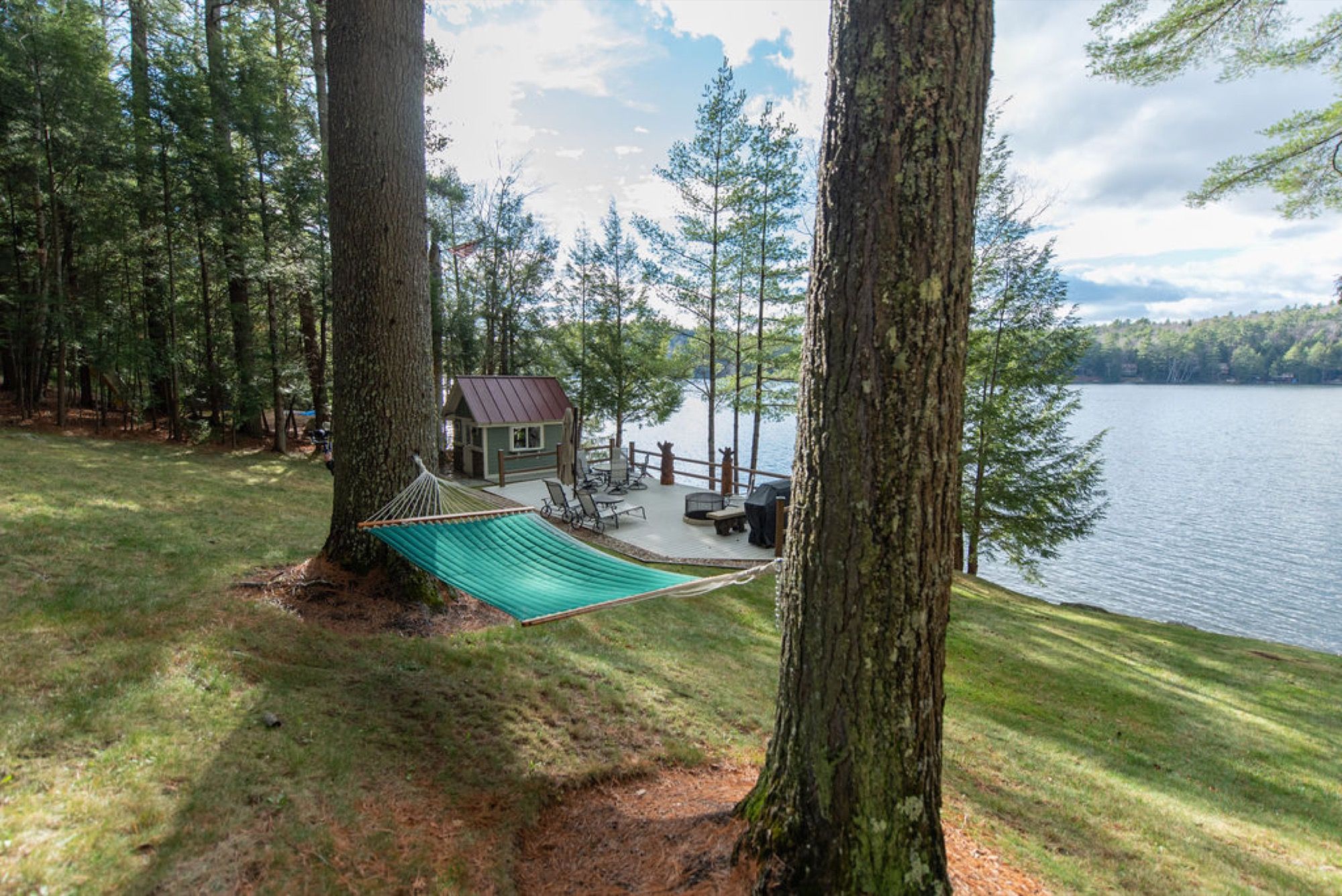 A hammock strung between pines above the boathouse deck at Camp Sunnyside.