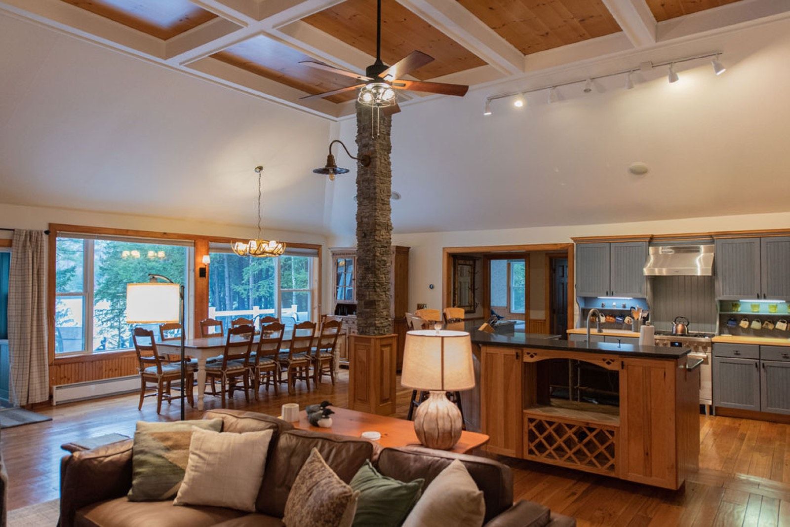 The open kitchen and long dining table under the coffered pine ceiling in the main house at Camp Sunnyside, set for a large family.